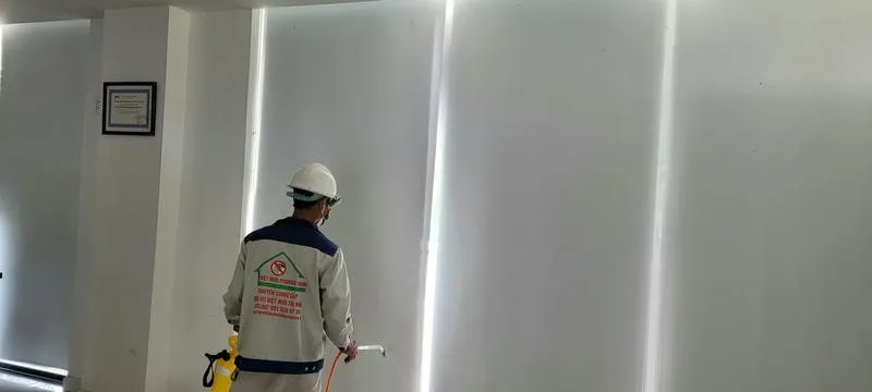 Nhân viên phun thuốc diệt muỗi tại nhà với thiết bị chuyên nghiệp